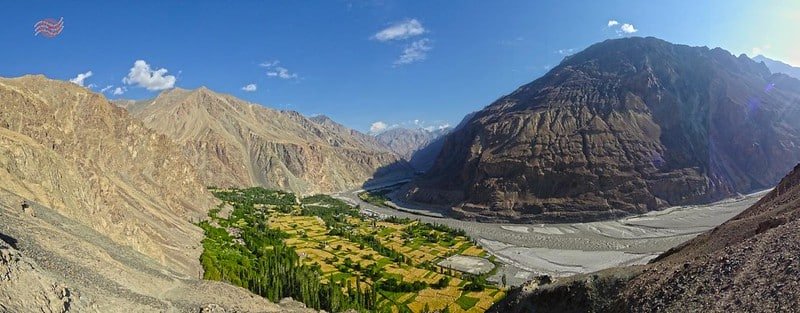 Green valley with farmland and river between arid mountains in thang, turtuk