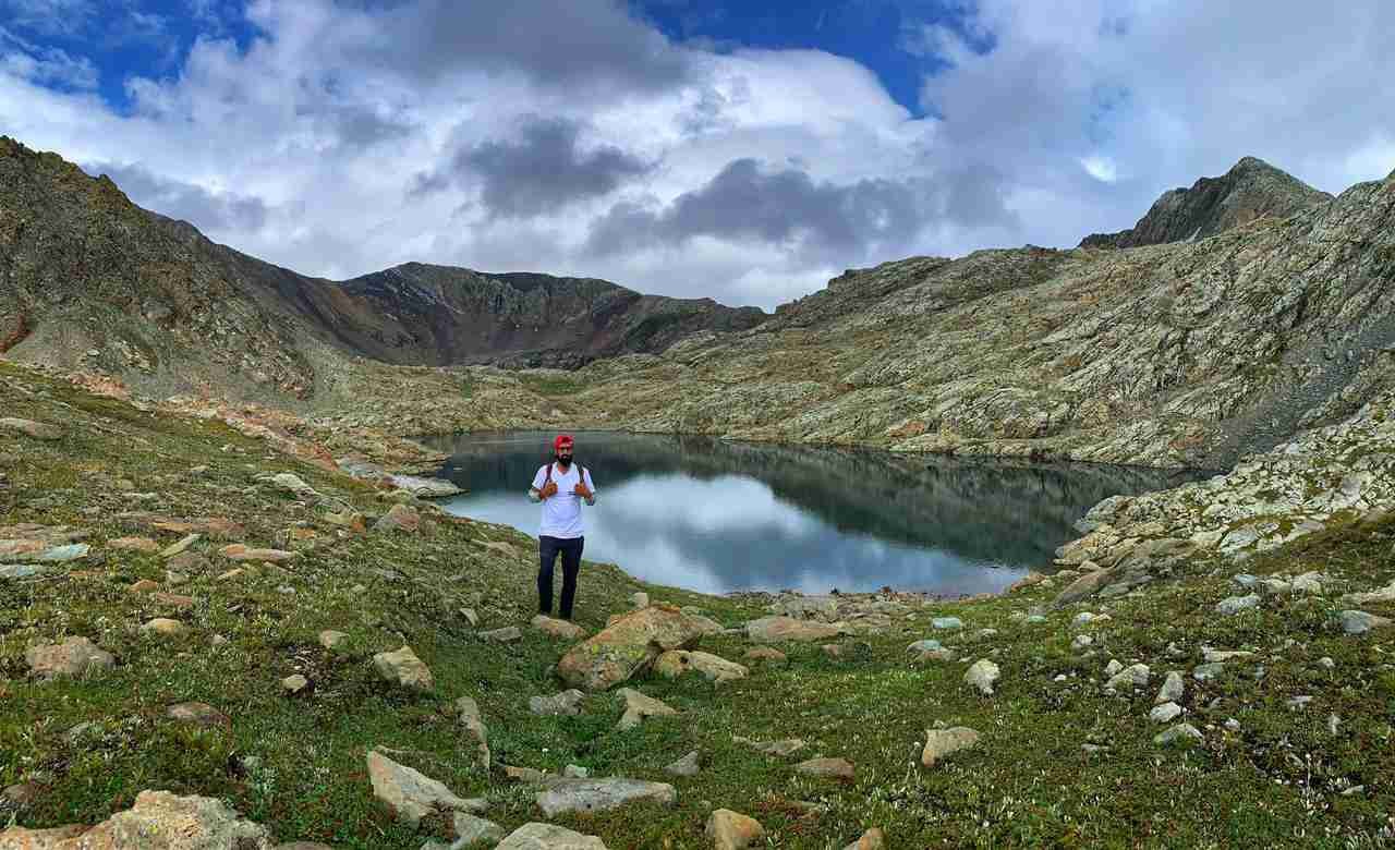 Man hiking near a mountain lake in Himachal Pradesh.