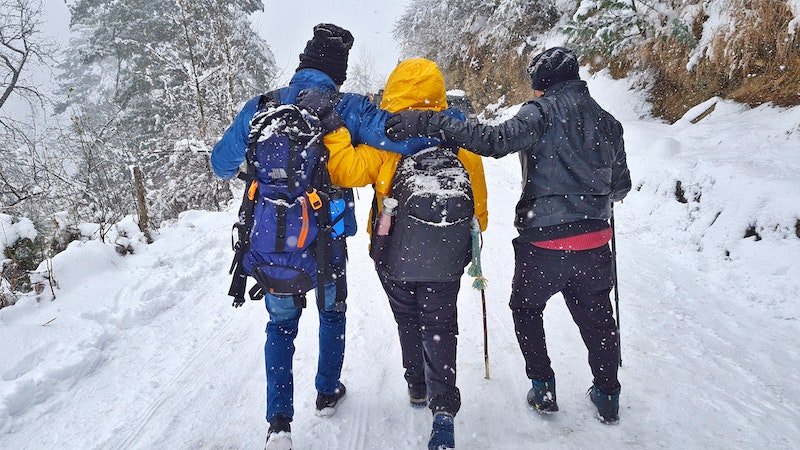 Group hiking through fresh Pahalgam winter snow