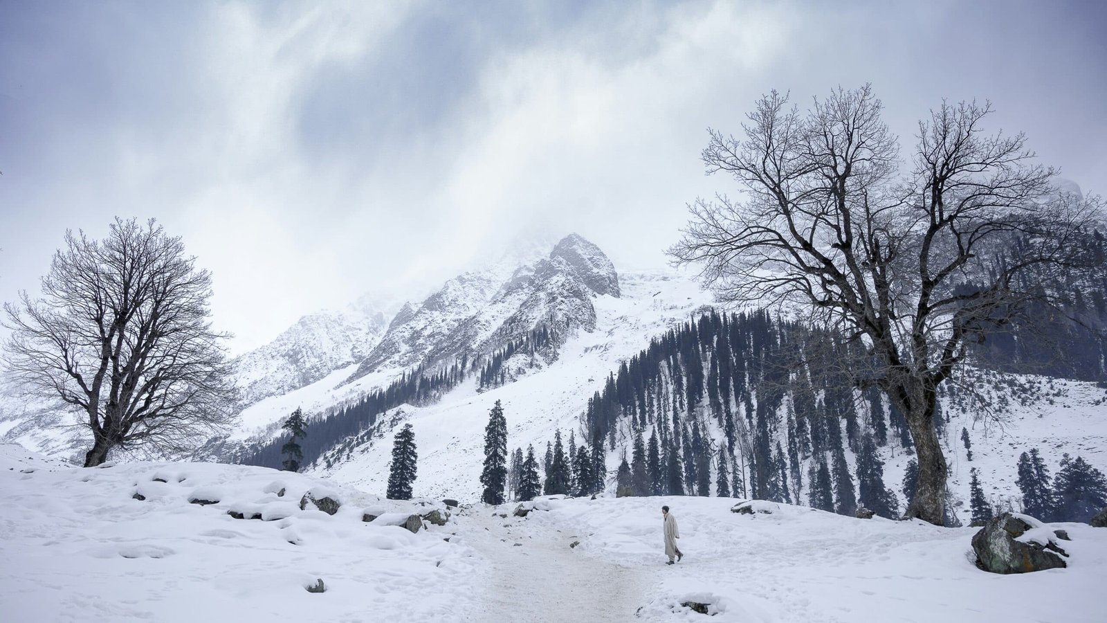 a man walking in the snow of gulmarg during winter month