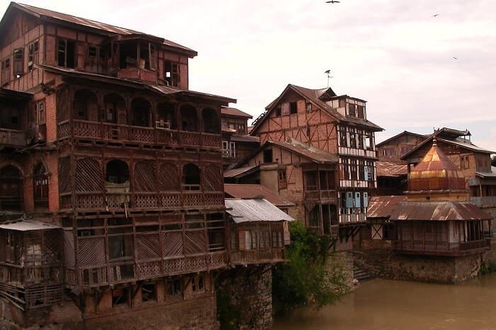 Traditional wooden houses overhanging a riverbank in srinagar