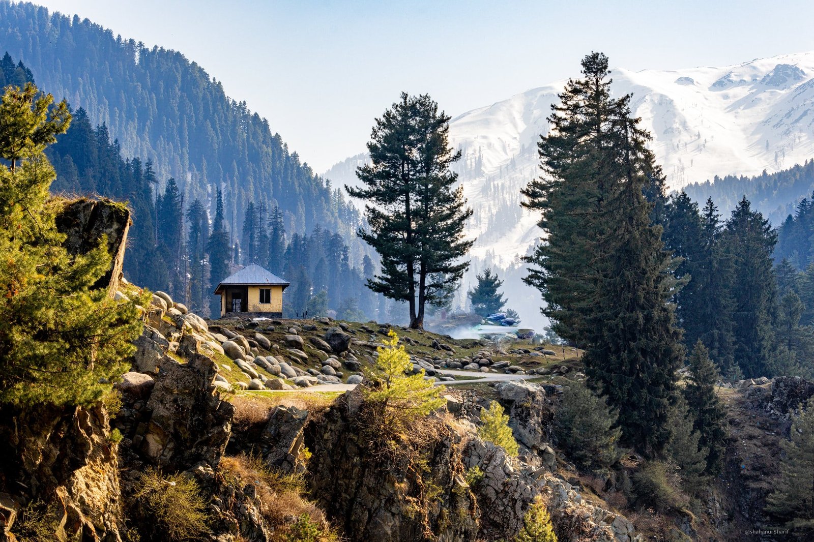 Scenic mountain landscape with a small hut and pine trees in Baisaran Valley