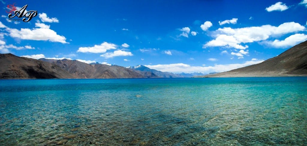 Crystal clear blue waters of Pangong Lake with surrounding mountains