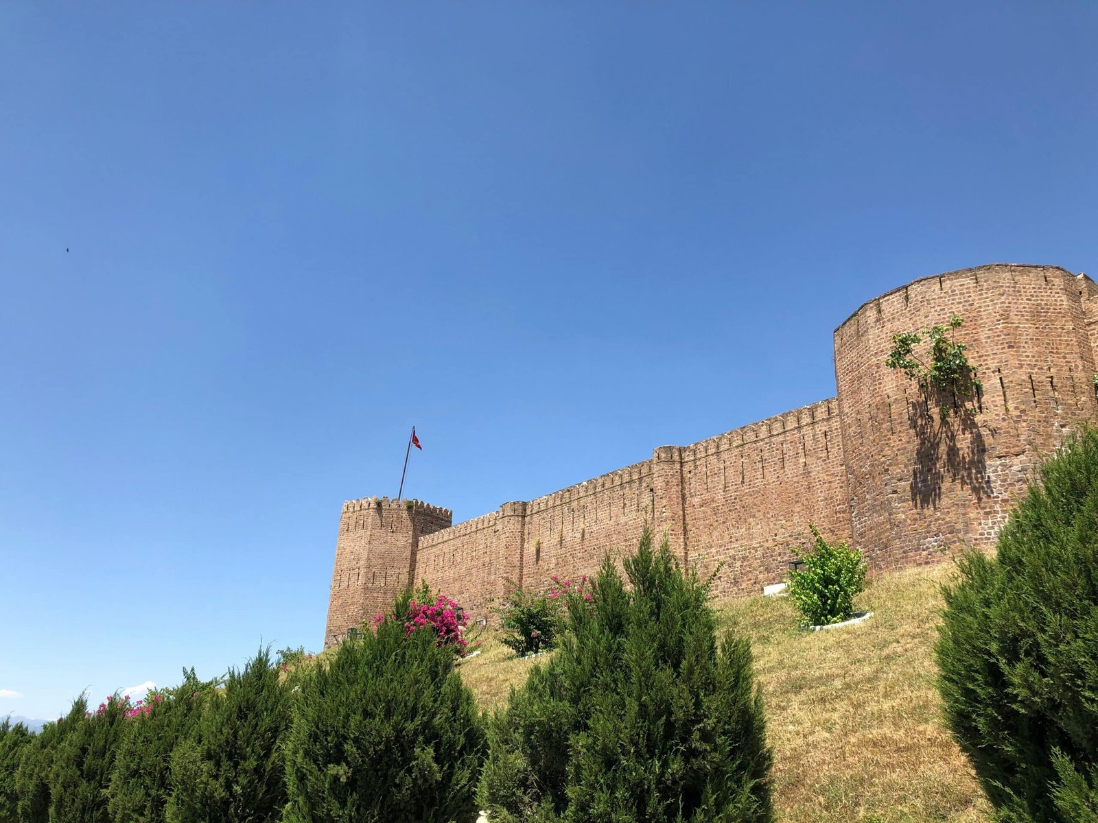 Bhimgarh Fort in Reasi with stone walls and a flag on top.