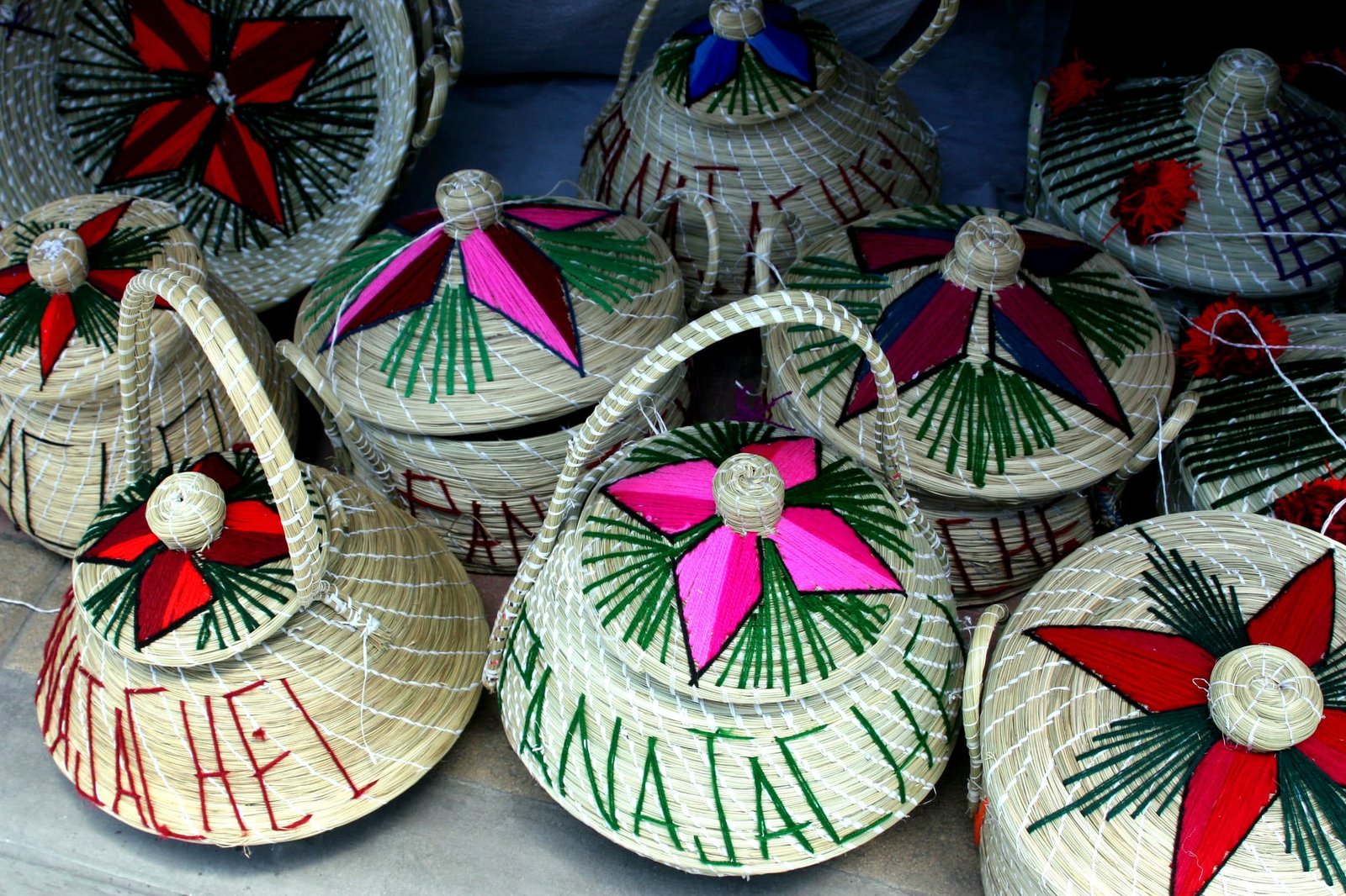 Colorful Kashmiri grass baskets with embroidered lids.