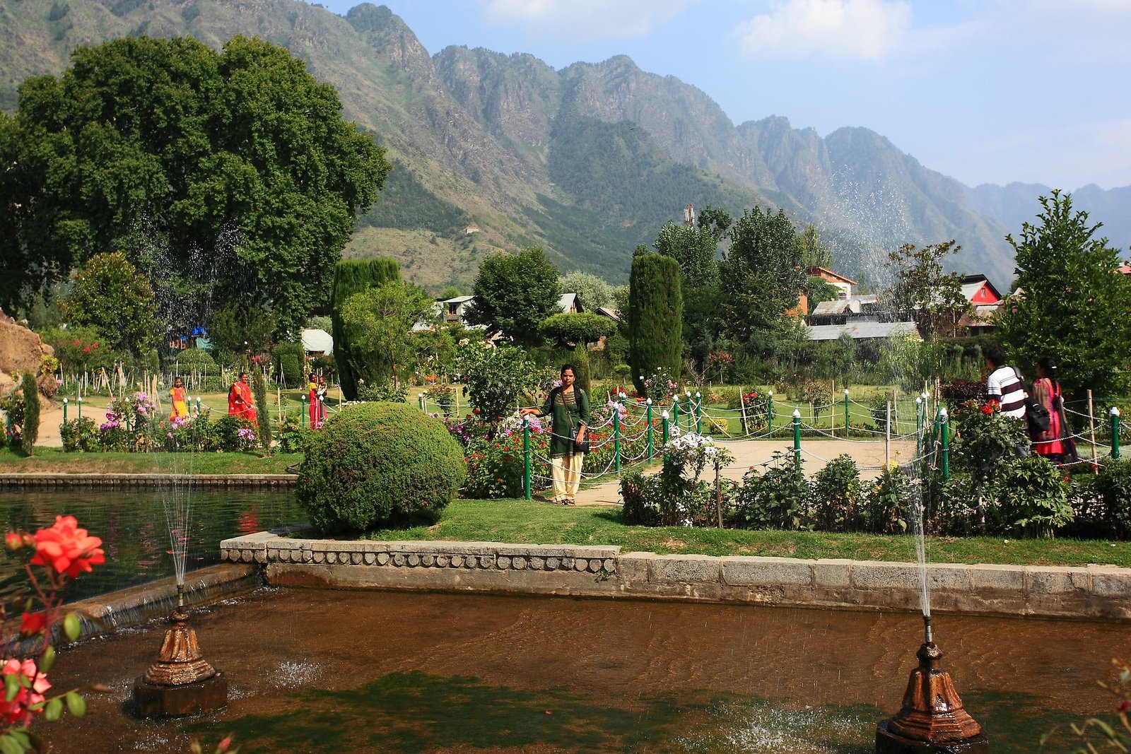 Nishat Garden with fountains, flowers, and mountains in the background