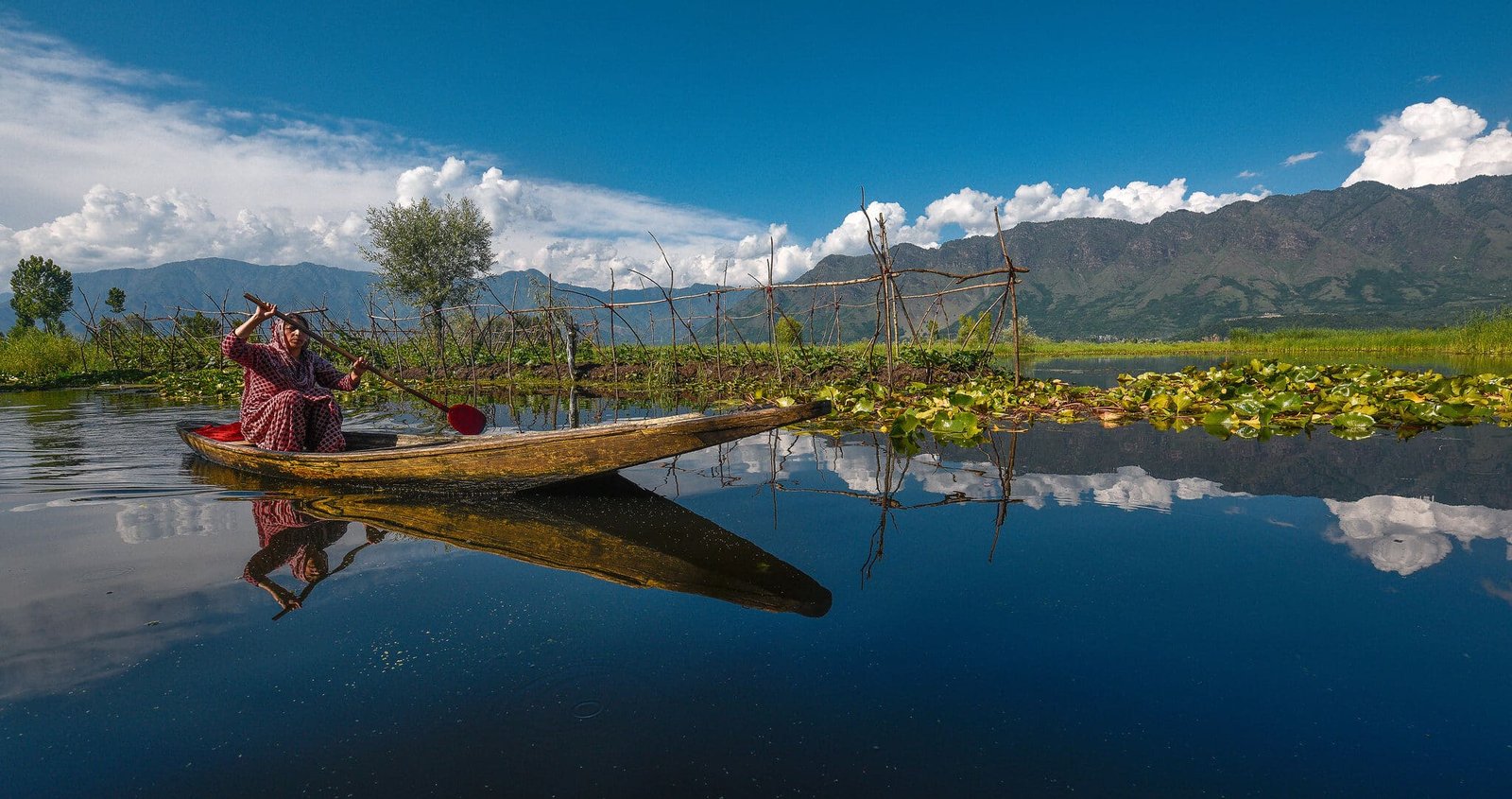 Woman rowing a wooden boat on dal lake in srinagar