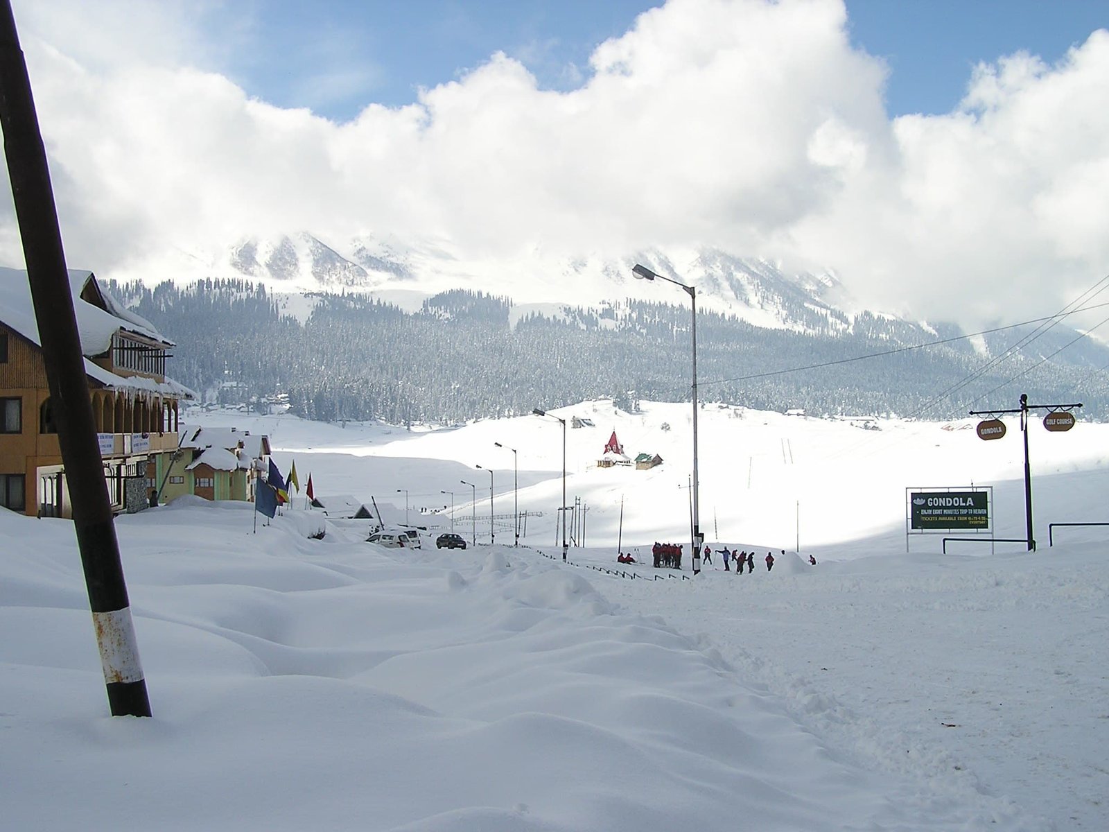 People enjoying in the snow near Gondola in Gulmarg with snow-covered road