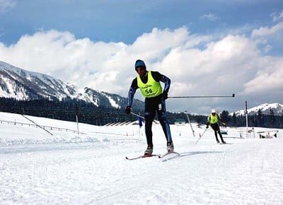 skiers racing on a snow-covered trail with proper skiing gear