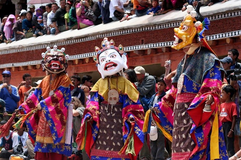 Masked dancers in colorful traditional costumes performing during the Hemis Festival in Ladakh