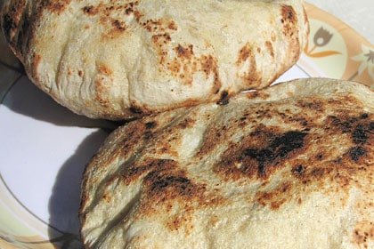 Close-up of two pieces of Khambir bread on a plate