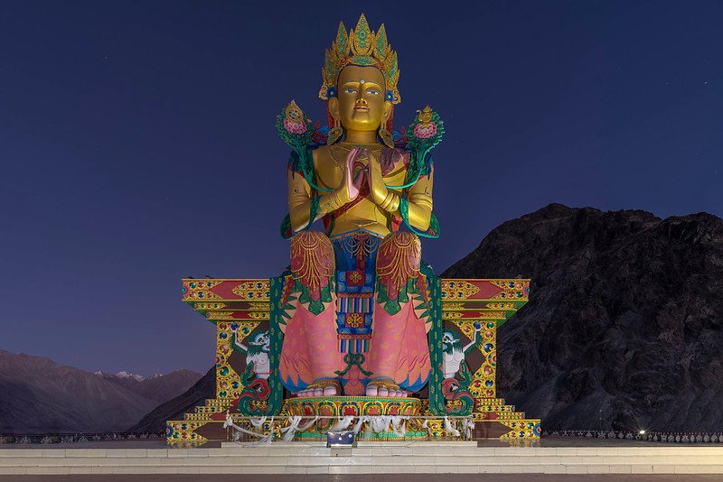 colorful statue of Maitreya Buddha seated in a meditative pose in nubra valley