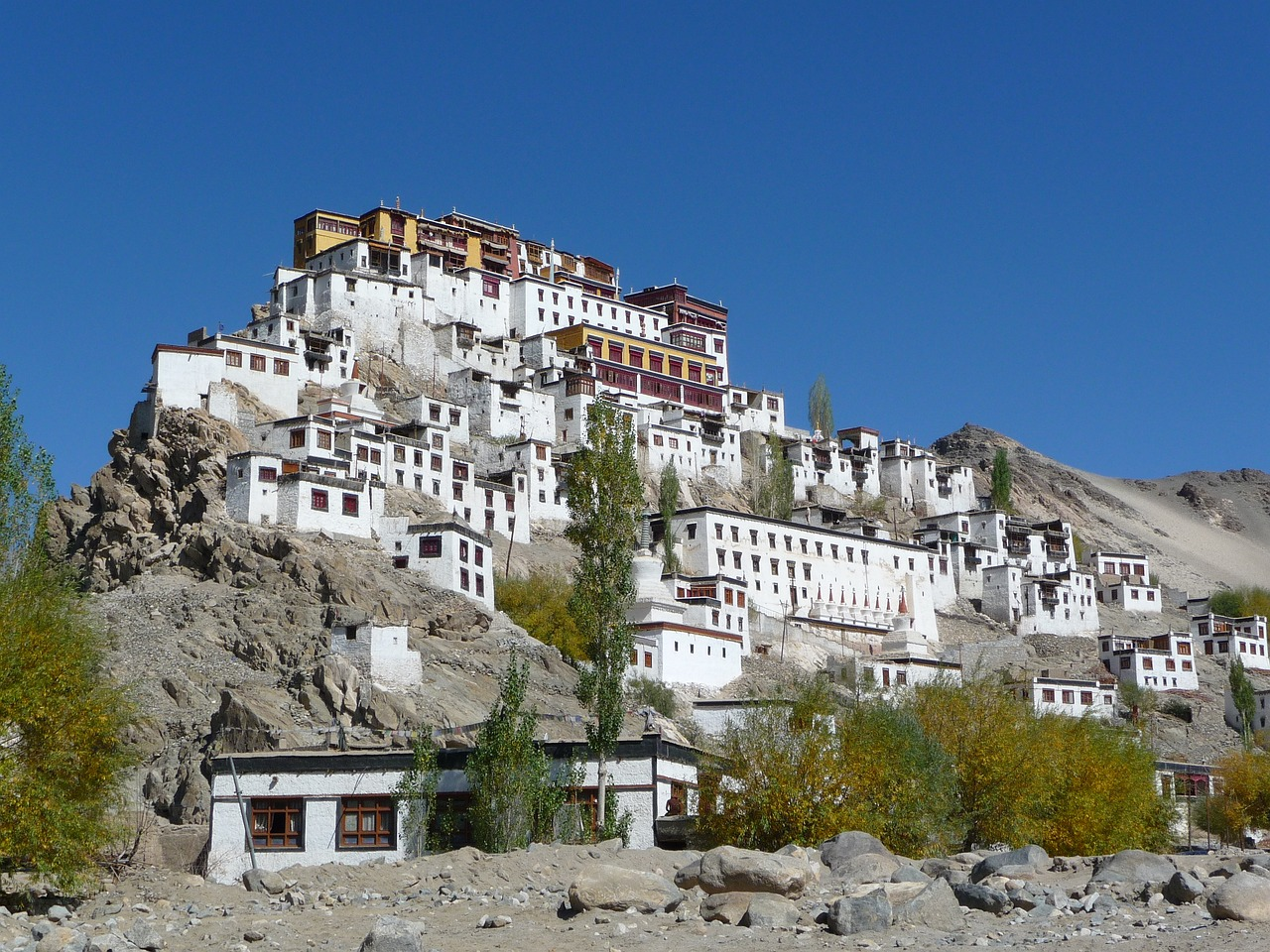 Alchi Monastery complex built on a hill with white buildings under a clear blue sky