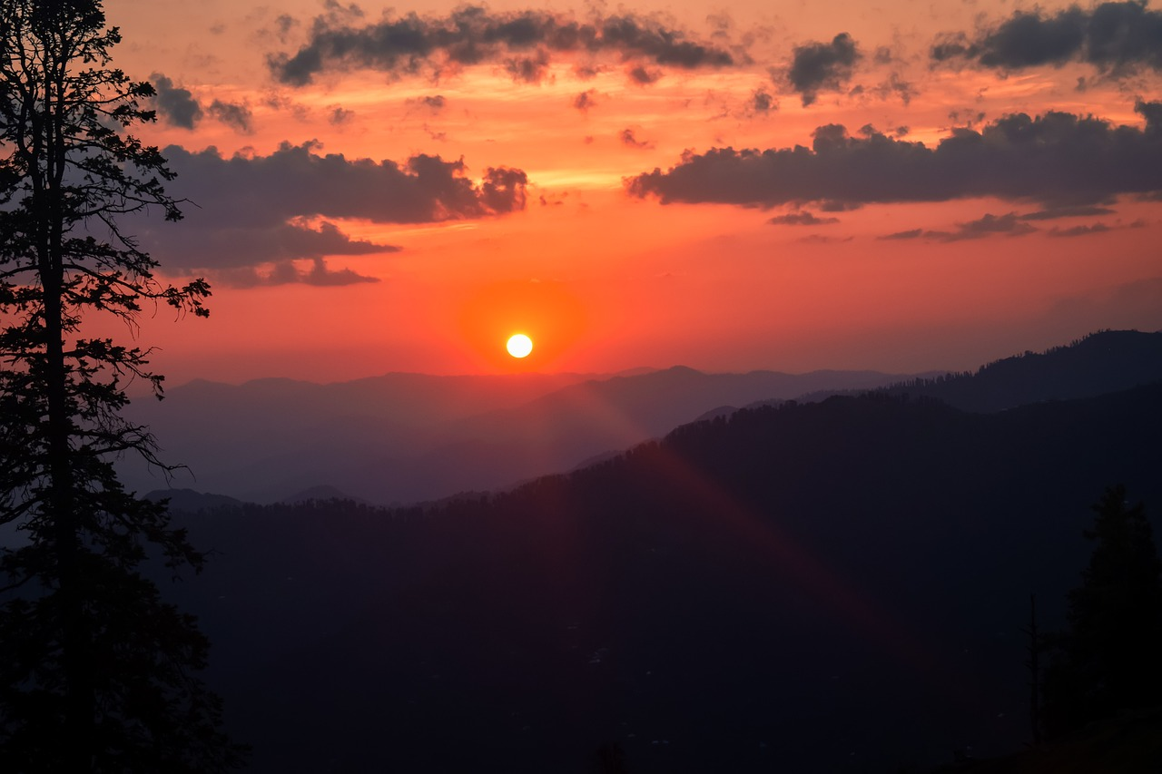Sunset over mountain ranges with glowing orange sky