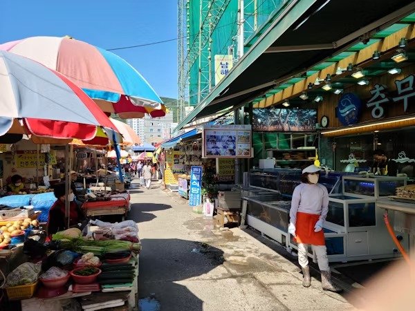 Outdoor market with stalls and shoppers under colorful umbrellas in Leh Ladakh