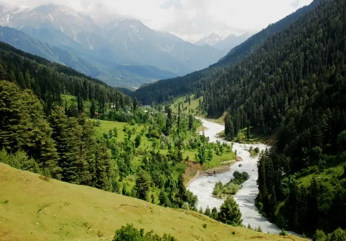 Beautiful Kashmir valley with river flowing through pine-covered hills